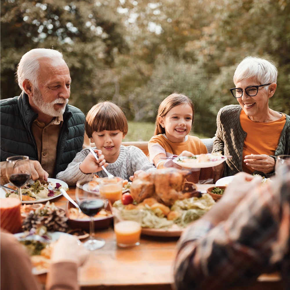 family eating a meal outside at a table