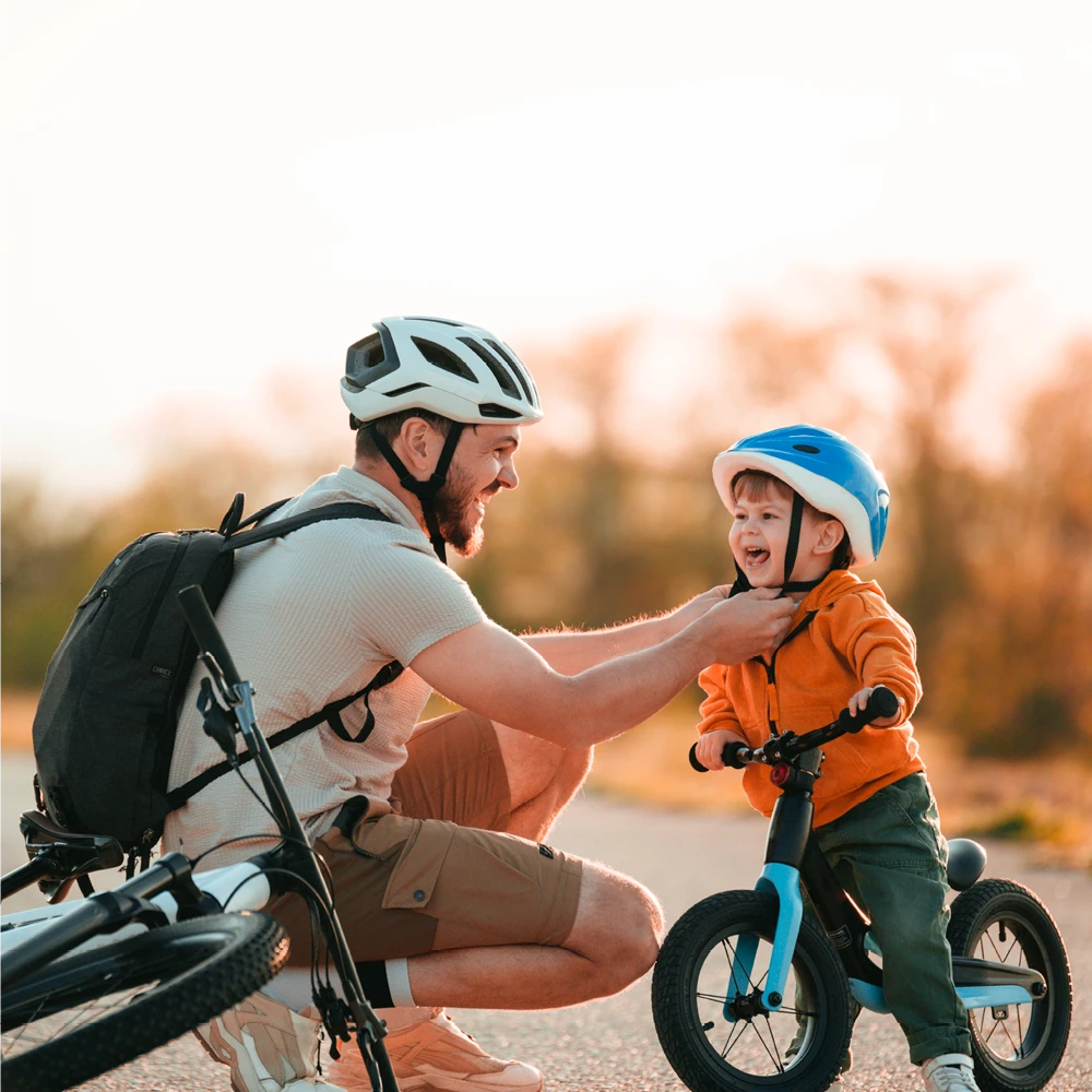 father helping his son ride a bike outdoors